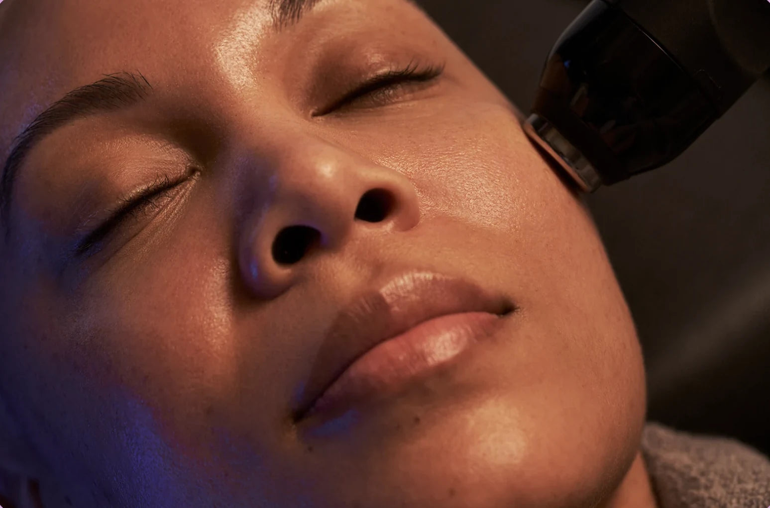 A relaxed face with the Facial Pen held at the temple