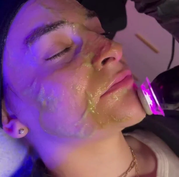 The pen gliding along a jawline through gel, purple light on
